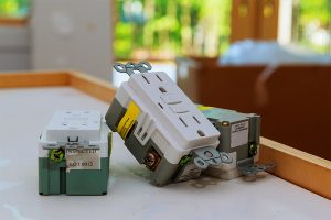 Electrical outlet and plug with exposed wiring on a table